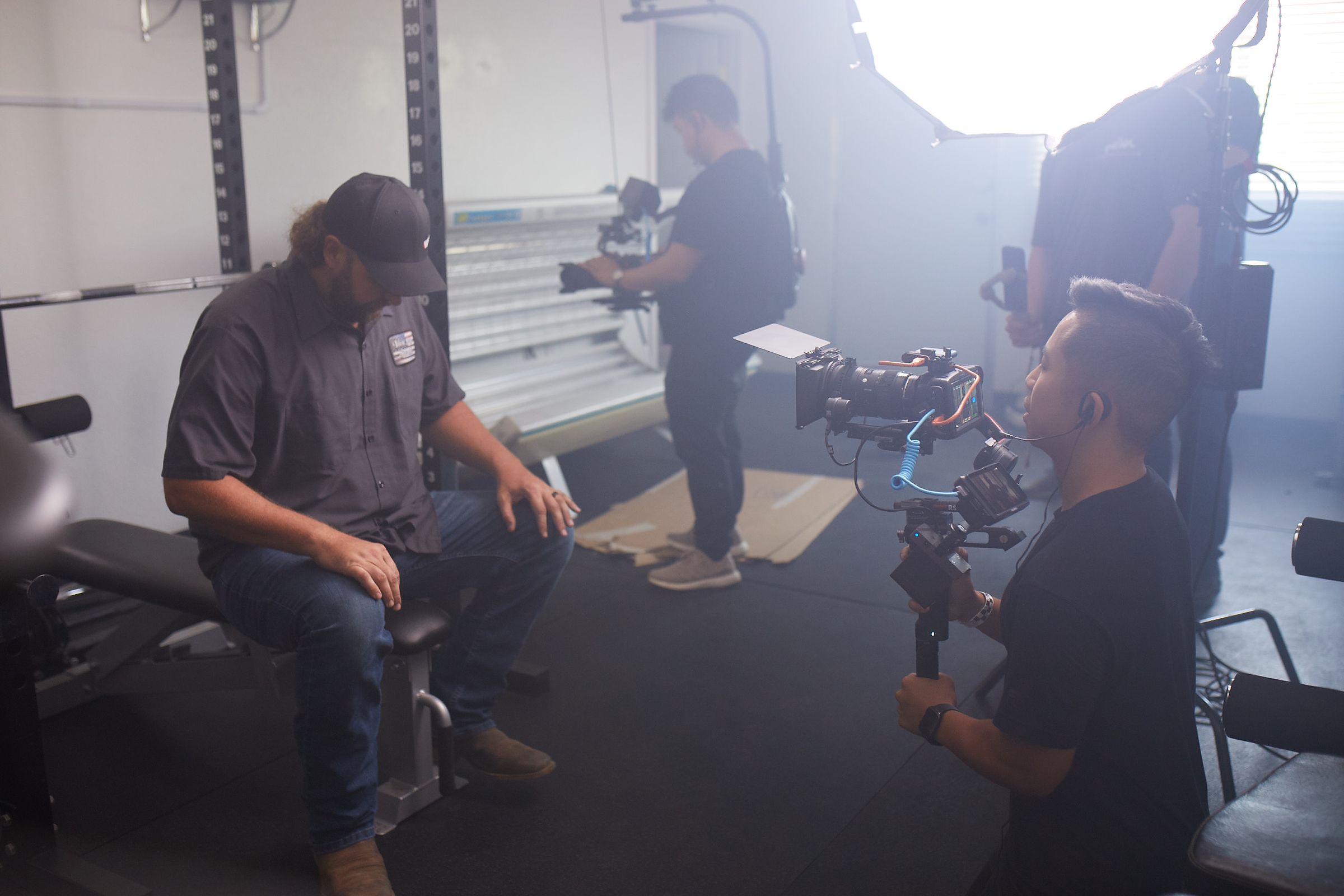 A compact production crew gathered with camera equipment in a studio