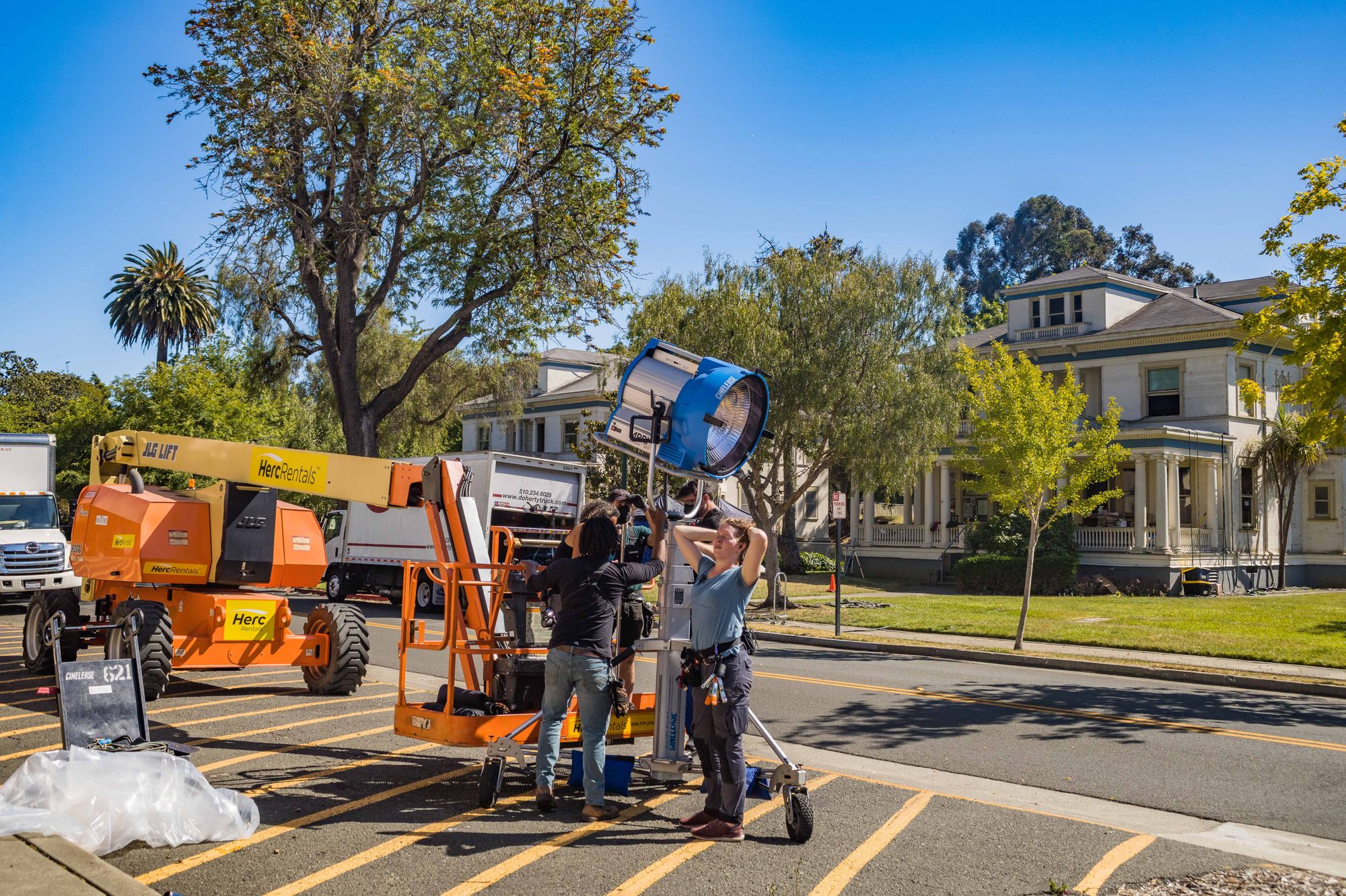 A location crew coordinating large-scale lighting equipment outdoors